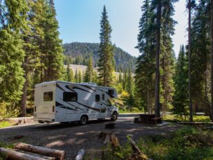 Beautiful campsite in the mountains with an RV and wooden bench. Fondsvermögen der Deutschen stellt Rekord ein beautiful campsite mountains with rv wooden bench scaled Versicherungspapa