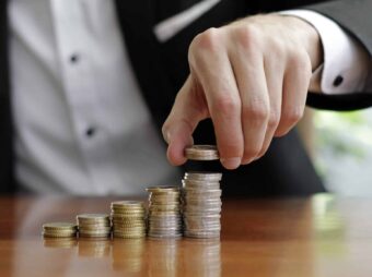 BGH stärkt Immobilienverkäufer in Notlagen closeup shot businessman s hands counting stacks coins after business success scaled Versicherungspapa