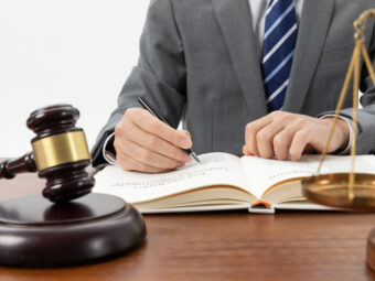 Deutsche Versicherer sind finanziell gut gerüstet closeup shot person writing book with gavel table 1 scaled Versicherungspapa
