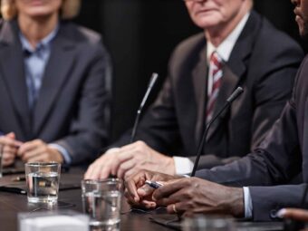 Hands of Black Man Sitting at Table while Speaking at Political Meeting BGH stärkt Immobilienverkäufer in Notlagen hands of black man sitting at table while speaking 2025 03 08 20 46 05 utc scaled Versicherungspapa