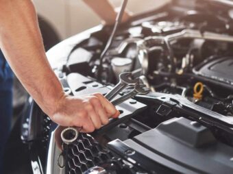 Picture showing muscular car service worker repairing vehicle BGH stärkt Immobilienverkäufer in Notlagen muskuloser autoservice arbeiter der fahrzeug repariert scaled Versicherungspapa