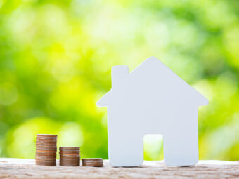 Nachhaltige Geldanlage: Momentum verloren? world habitat day close up picture pile coins model house scaled Versicherungspapa