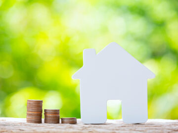 Startseite world habitat day close up picture pile coins model house scaled Versicherungspapa