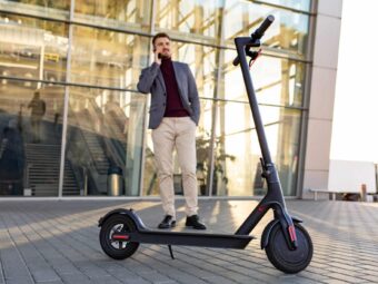 Young handsome man with e-scooter standing on sidewalk near the airport on the sunset and talking on the smartphone.Trendy urban transportation on modern electric scooter.Eco friendly mobility concep BGH stärkt Immobilienverkäufer in Notlagen young handsome man with e scooter standing sidewalk near airport sunset talking smartphone 1 scaled Versicherungspapa
