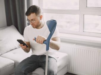 Jede siebte Unfallversicherung erhält Top-Note young man with broken leg home using smartphone scaled scaled Versicherungspapa