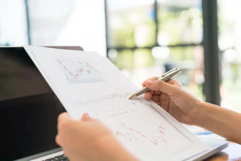 Wie die Generationen bei der Geldanlage ticken business woman hand with financial charts laptop table Versicherungspapa