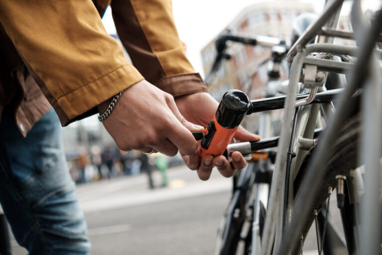 Fahrraddiebstähle: Fallzahl gesunken – Kosten gestiegen cyclist securing bike with u lock on city street 2025 04 21 17 11 09 utc scaled Versicherungspapa