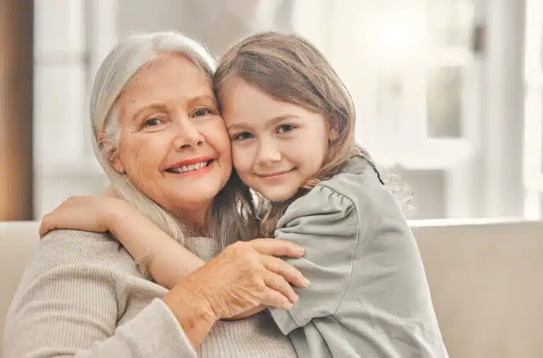 Digitale Rentenübersicht bisher verhalten genutzt grandma girl portrait sofa hug love relationship development home senior woman grandchild bonding couch family values womens day weekend relax living room scaled Versicherungspapa