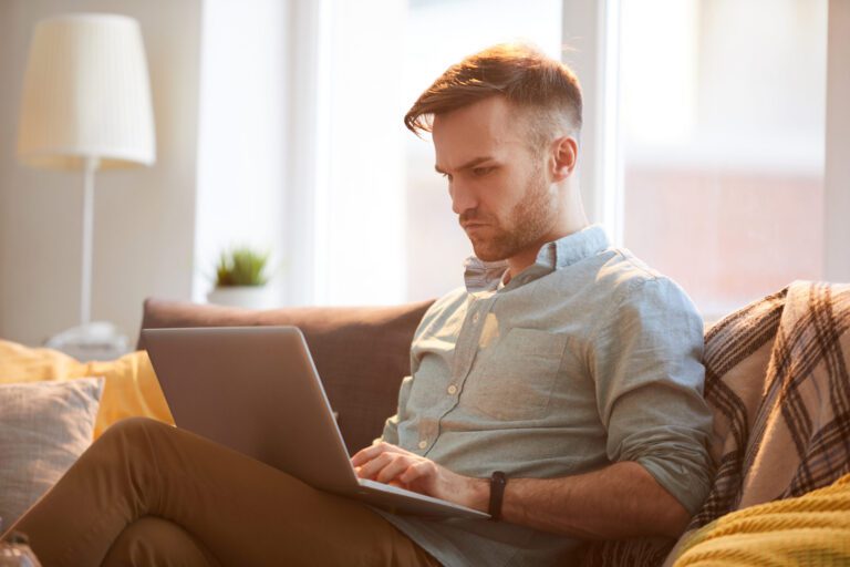 „Bis zu 200 Prozent mehr rausholen“? Vorsicht vor Rückabwicklern! handsome man using laptop home scaled Versicherungspapa