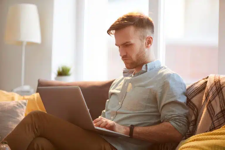 „Bis zu 200 Prozent mehr rausholen“? Vorsicht vor Rückabwicklern! handsome man using laptop home scaled Versicherungspapa